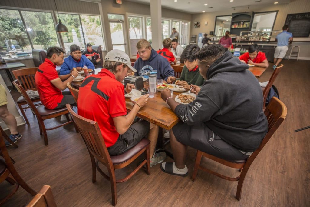 IJGA student athletes eating in the dining hall around a shared table