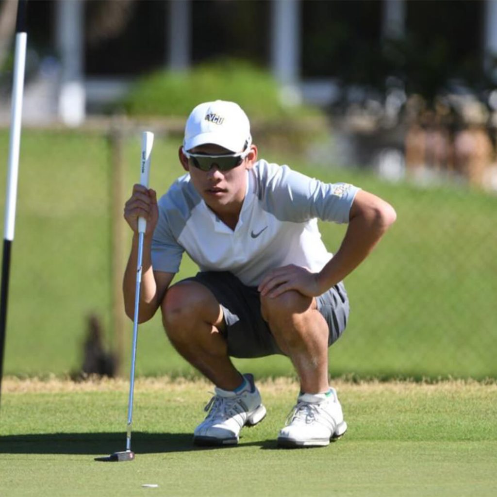 Golfer, Ian Peng squats down on the greens