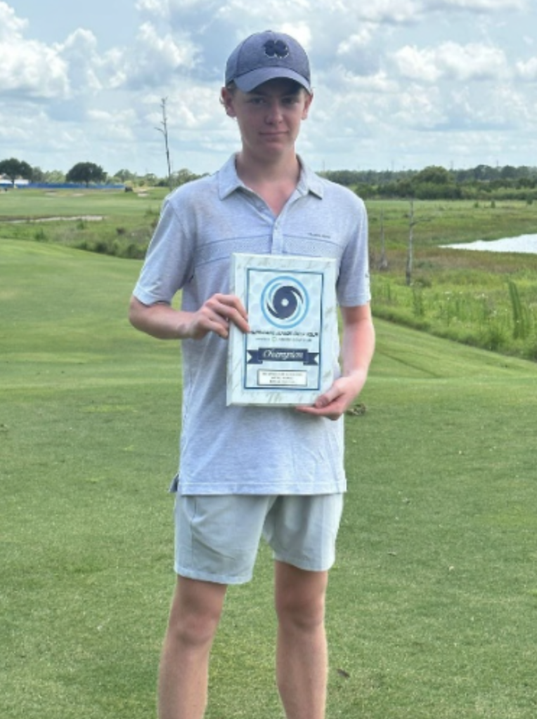 IJGA golfer Alex Shelley holds his championship award 