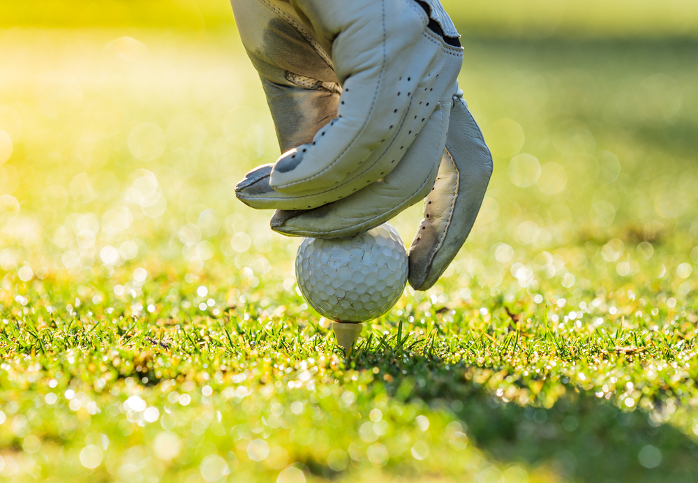 Close up photo of golfer putting a ball on a tee