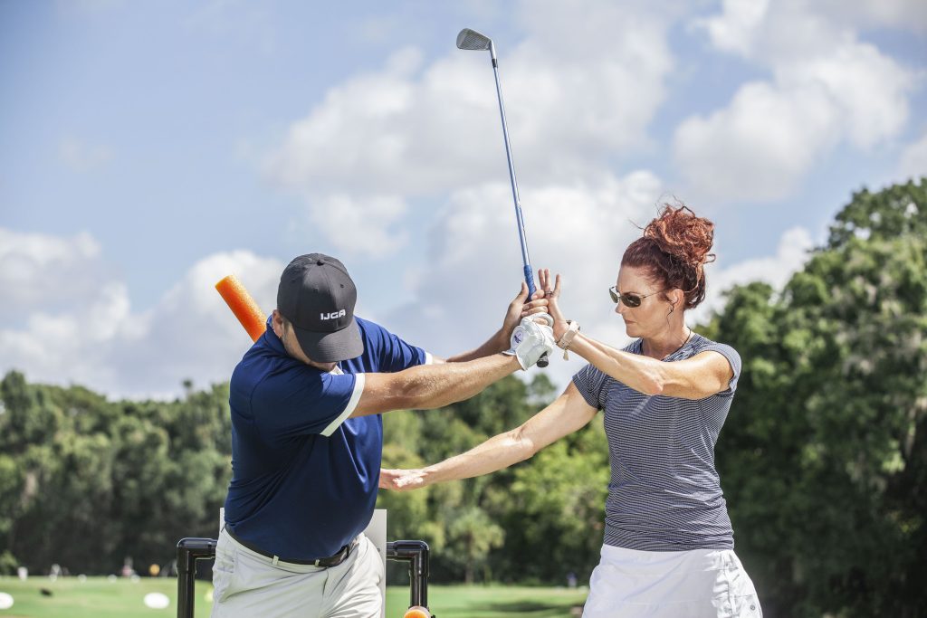 IJGA coach helps golfer on the course