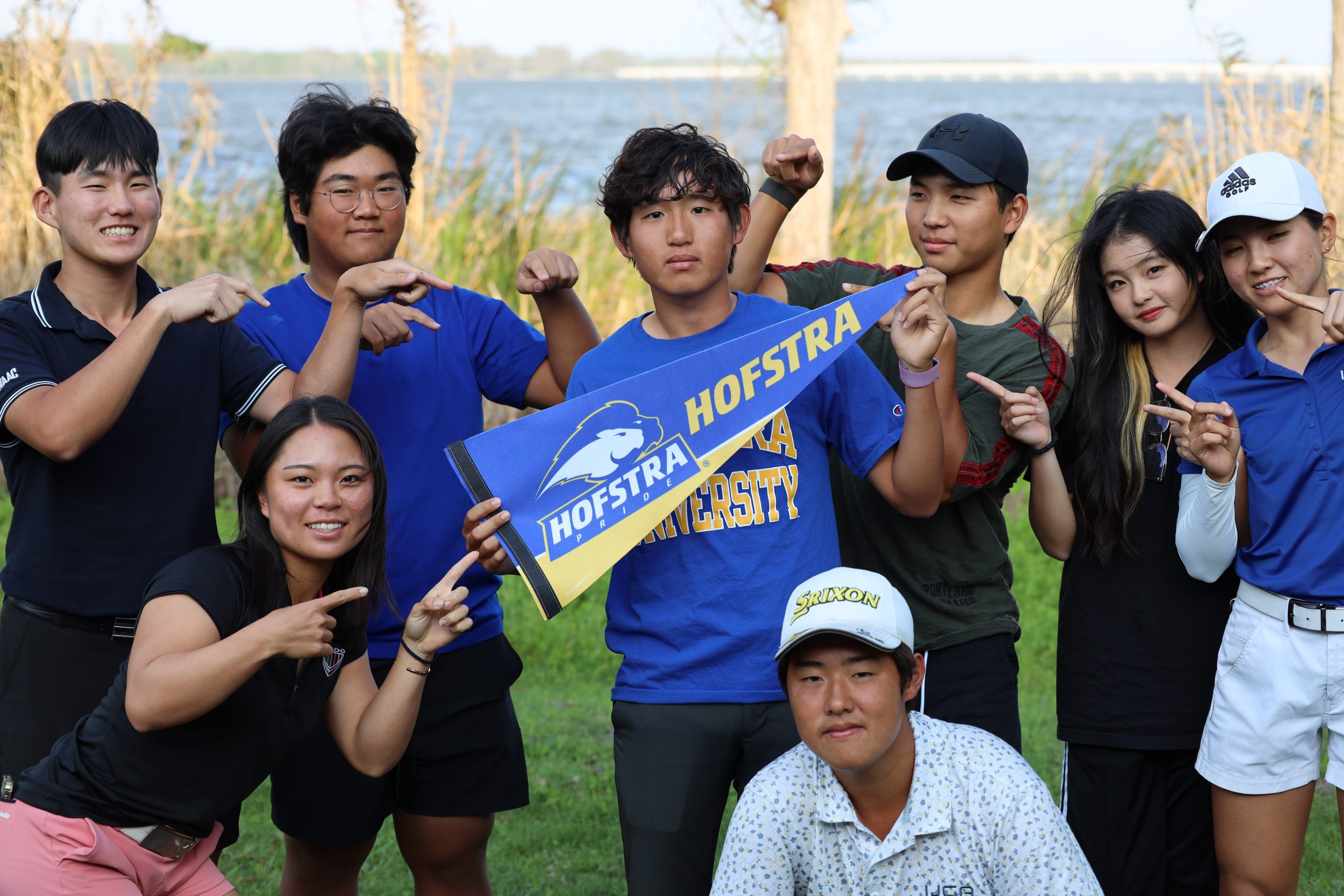 IJGA golfers hold up a college pennant